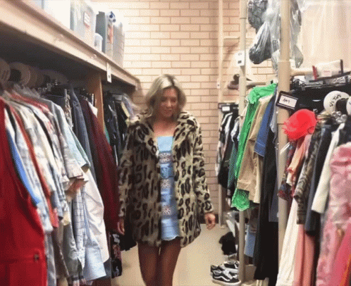 Woman In Leopard Print Coat Walking Through Closet GIF