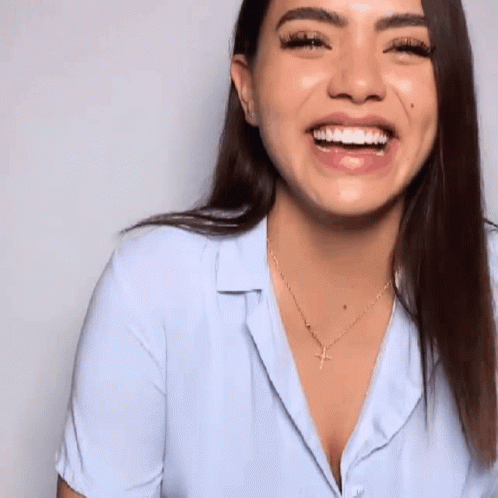 Woman in Light Blue Shirt and Gold Necklace Smiling