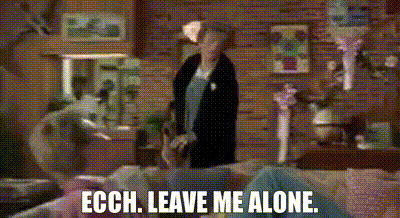 Woman in Living Room Next to Couch Saying Leave Me Alone