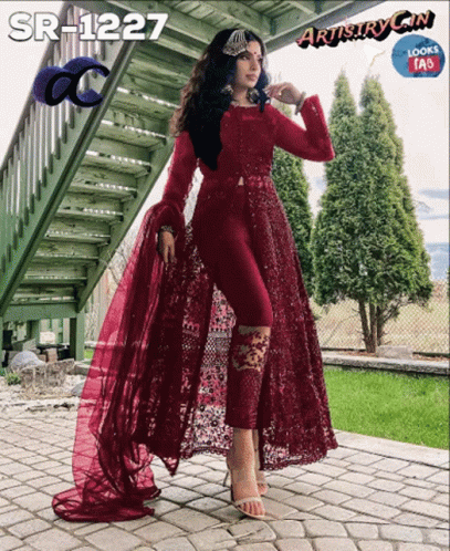 Woman in Maroon Dress Standing in Front of Staircase