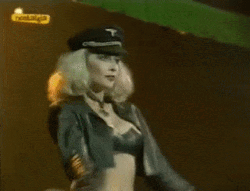 Woman in Military Hat Dancing by Nostalgia Sign
