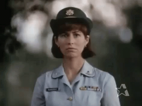 Woman in Military Uniform Standing in Front of Tree