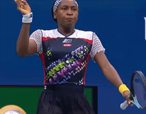 Woman in New Balance Shirt Pointing Up at usopen.org Sign