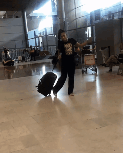 Woman in Nike T-Shirt Holding Suitcase at Airport