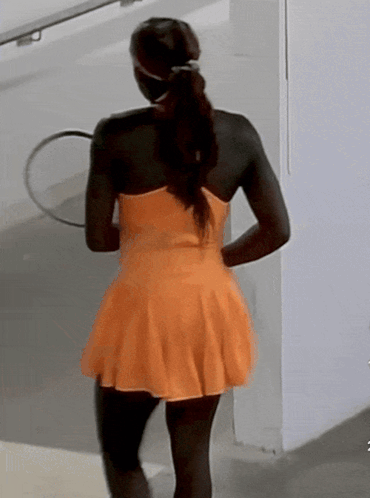 Woman in Orange Dress Holding Tennis Racquet