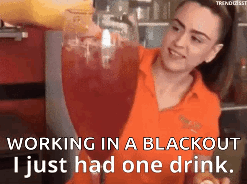Woman in Orange Shirt Pouring Drink Into Glass
