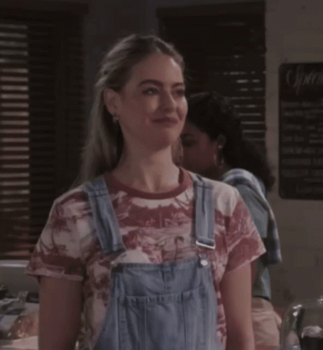 Woman In Overalls And Tie-Dye Shirt With Sprite Sign GIF