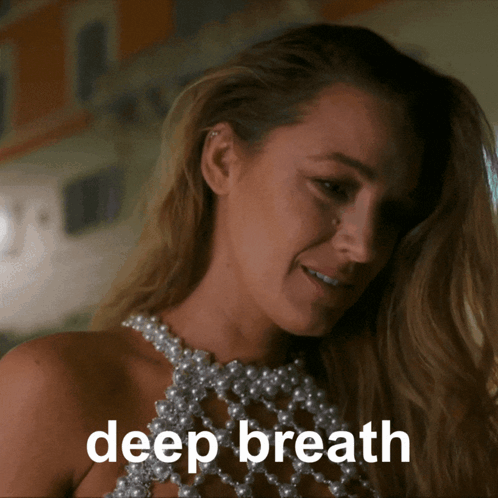 Woman In Pearl Top Saying Deep Breath GIF