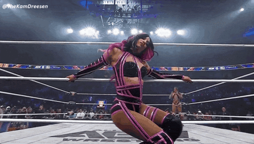 Woman in Pink and Black Wrestling Outfit Kneeling in Ring