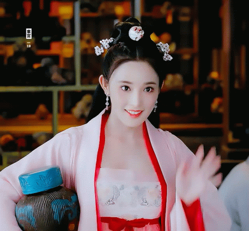 Woman In Pink And Red Costume Holding Bottle GIF