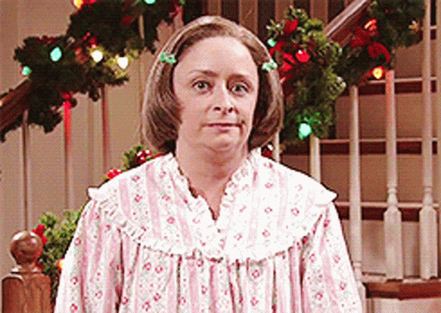 Woman In Pink And White Dress In Front Of Christmas Tree GIF