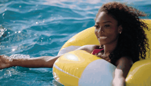 Woman In Pink Bikini Floating On Yellow Float GIF