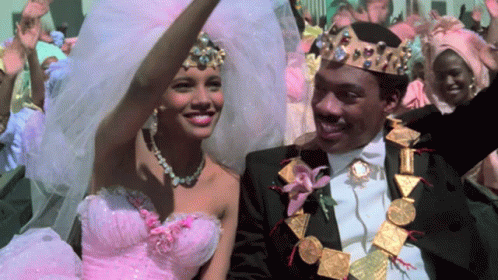 Woman In Pink Dress And Man In Black Suit Smiling GIF