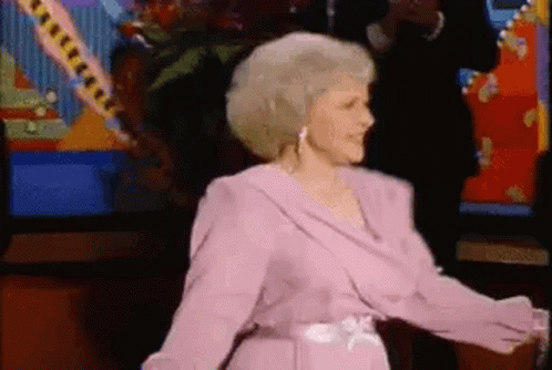 Woman in Pink Dress Dancing in Front of Television