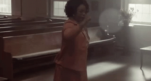 Woman In Pink Dress Hands Up In Church GIF