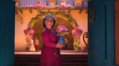 Woman in Pink Dress Holding Vase of Flowers