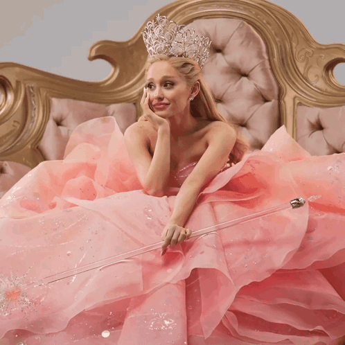 Woman In Pink Dress Holding Wand On Couch GIF