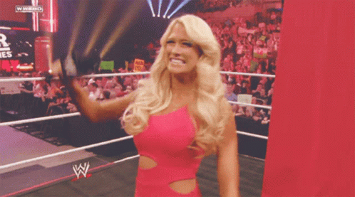 Woman in Pink Dress in Wrestling Ring With WWE Logo