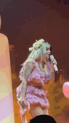 Woman in Pink Dress Singing on Stage
