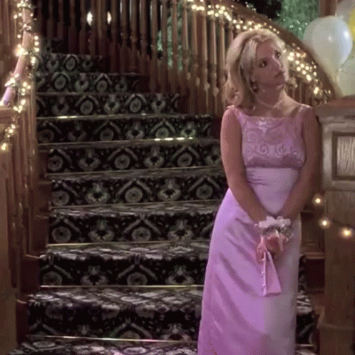 Woman in Pink Dress Standing in Front of Stairs