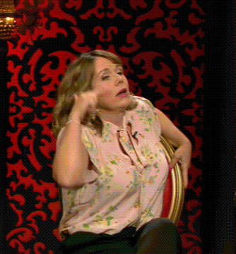 Woman In Pink Floral Shirt Before Red And Black Wall GIF