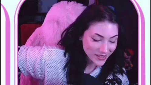 Woman in Pink Furry Jacket Eyes Closed at Mirror