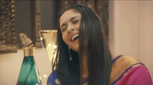 Woman in Pink Gold Sari Laughing Hair in Mouth