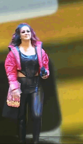 Woman in Pink Jacket and Black Pants Walking Down Street