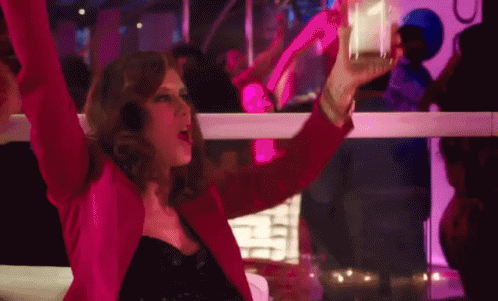 Woman In Pink Jacket Holding Glass At Club GIF