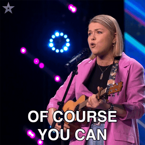 Woman in Pink Jacket Singing Into Microphone