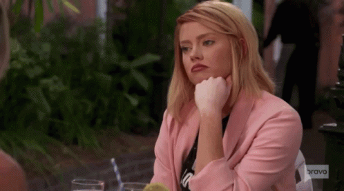 Woman In Pink Jacket Sitting At Table GIF