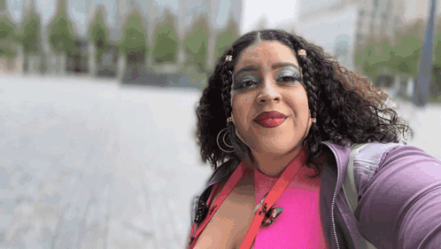 Woman in Pink Shirt and Purple Jacket Smiling