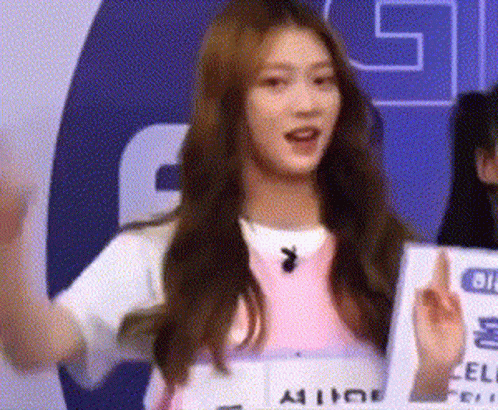 Woman in Pink Shirt at G Sign