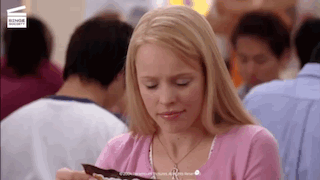 Woman in Pink Shirt Eating Chocolate in Crowded Restaurant