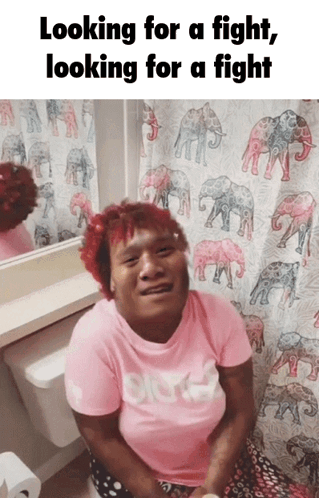 Woman in Pink Shirt on Toilet With Elephant Shower Curtain