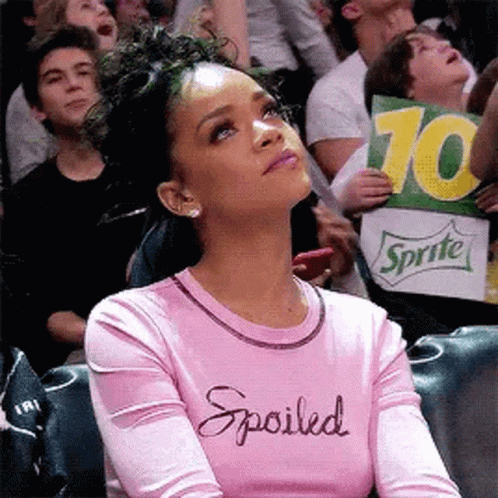 Woman in Pink Shirt Saying Spoiled Holding Sprite Sign in Crowd
