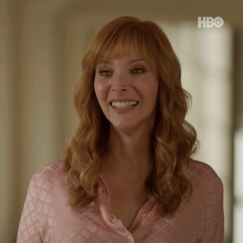 Woman in Pink Shirt Smiling at HBO Sign