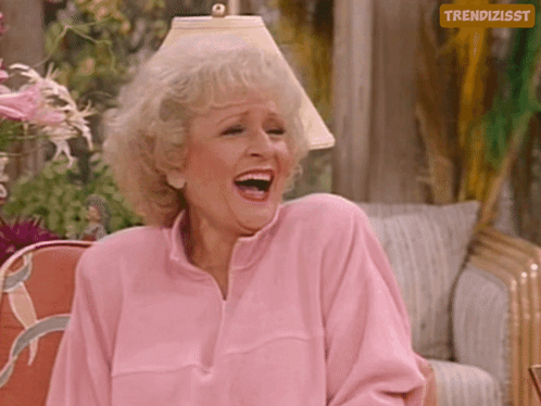 Woman In Pink Sweater Laughing In Front Of Trendizsst Sign GIF