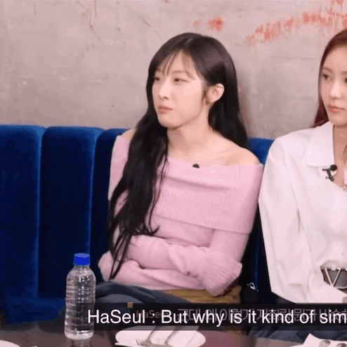 Woman in Pink Sweater Next to Woman in White Saying Haseul