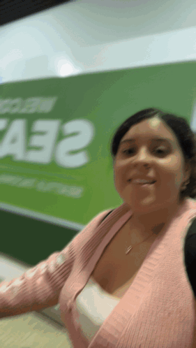 Woman in Pink Sweater Smiling in Front of A33 Sign