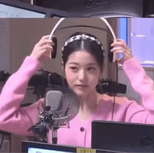 Woman in Pink Sweater Wearing Headphones