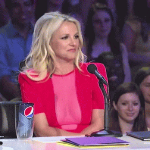 Woman in Pink Top Sitting at Table With Pepsi Cup