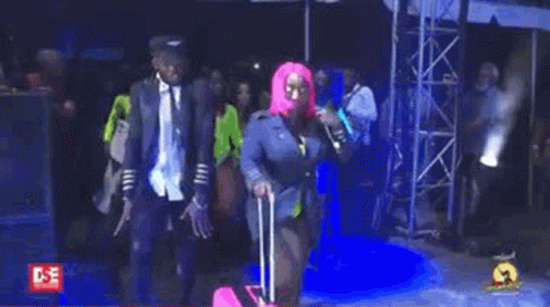 Woman in Pink Wig Walking With Pink Suitcase