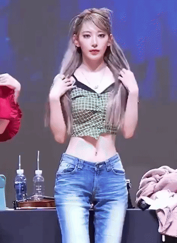Woman in Plaid Crop Top and Jeans Standing at Table