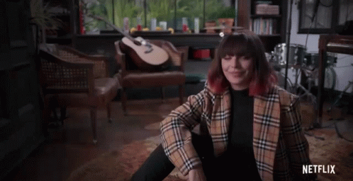 Woman in Plaid Jacket with Guitar and Netflix