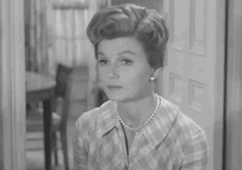 Woman in Plaid Shirt and Pearls Sitting by Door
