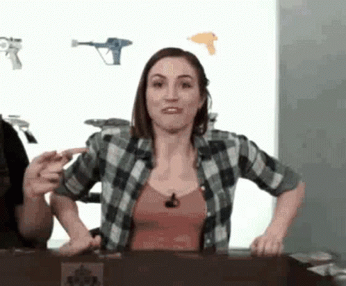 Woman in Plaid Shirt at Table With Man Behind