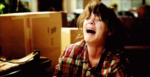 Woman in Plaid Shirt Crying in Front of Fragile Box