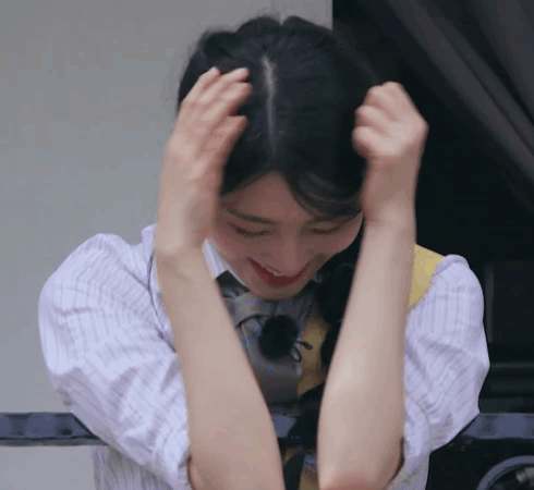 Woman In Plaid Shirt Holding Hair GIF