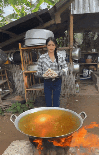 Woman in Plaid Shirt Holding Tray Near Large Pot